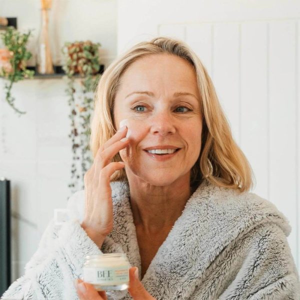 Woman applying Bee Cosmetics rejuvenating facial cream to her cheek