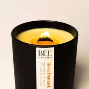 Close-up of a Bee Cosmetics rose beeswax candle with a wooden wick