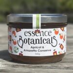 Essence Botanicals apricot and amaretto conserve jar on a wooden surface