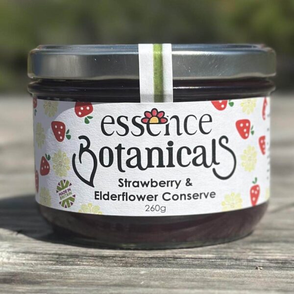 Essence Botanicals strawberry and elderflower conserve jar on a wooden surface